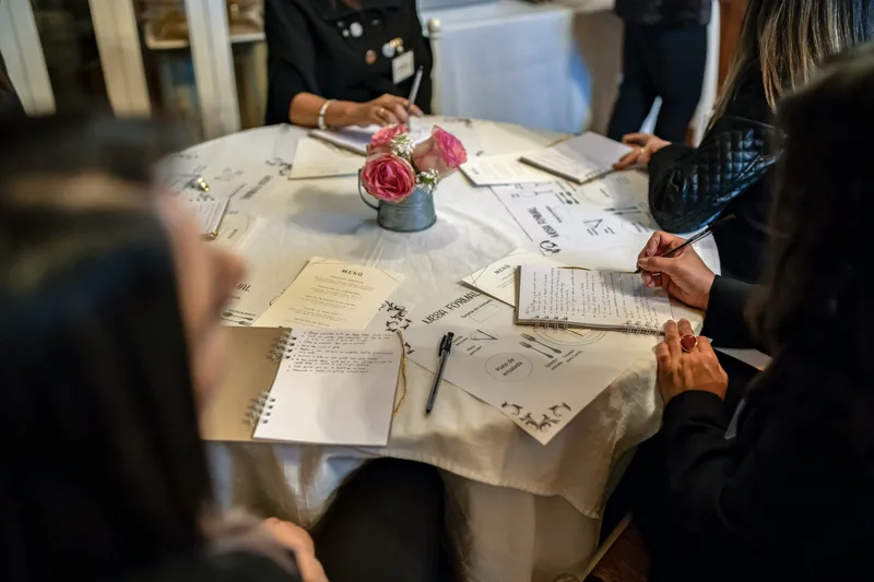 People working through printed worksheets together around a table.